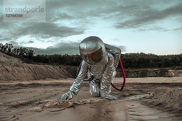 Spaceman exploring nameless planet  searching the soil