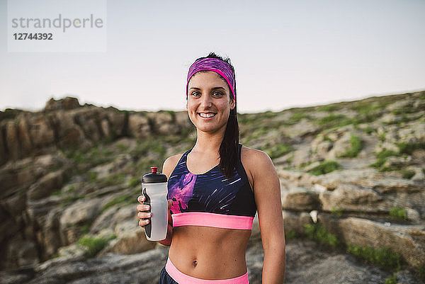 Portrait of an athlete woman drinking water outdoors