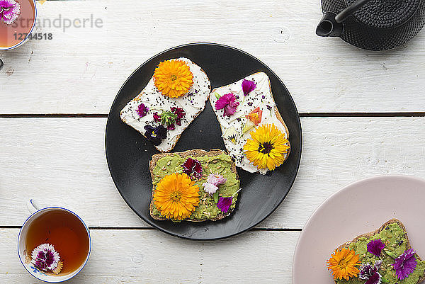 Toast with avocado hummus and sprad cheese with edible flowers