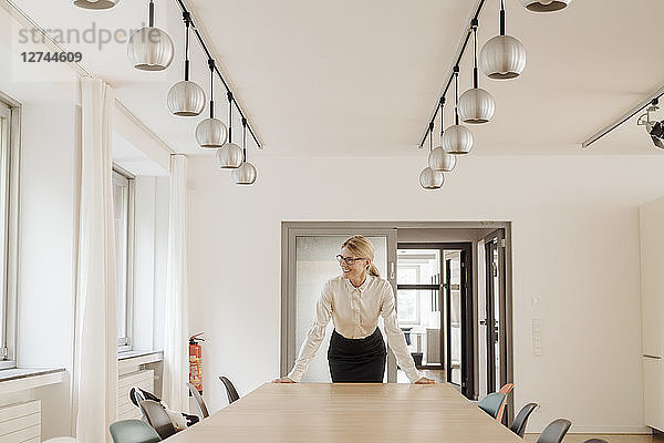 Smiling businesswoman standing in conference room