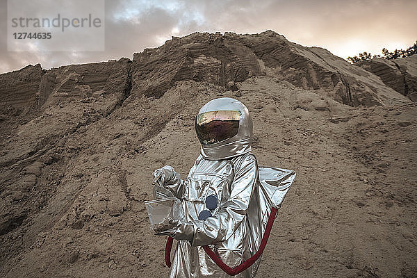 Spaceman on nameless planet taking samples of sand