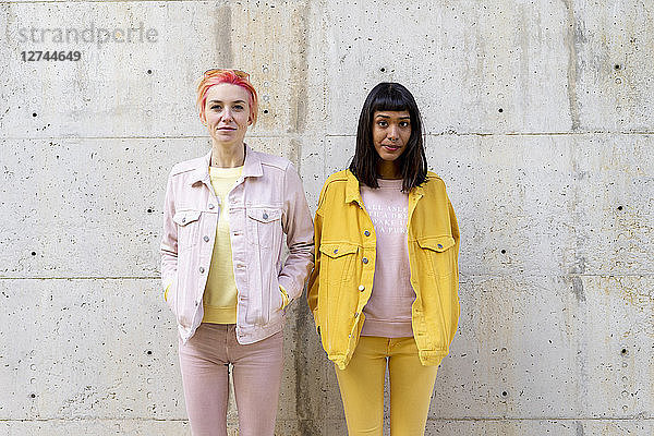 Two alternative friends having fun  wearing yellow and pink jeans clothes