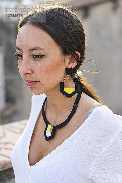 Portrait of young woman wearing modern necklace and earring