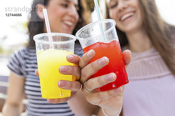 Close-up of two female friends enjoying a fresh slush