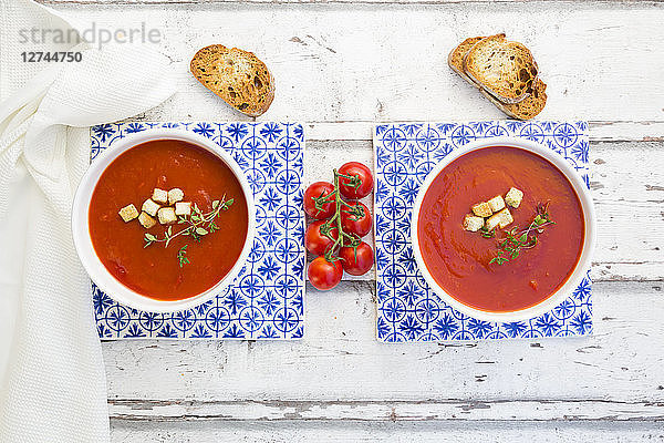Tomato soup with roasted bread  croutons and thyme  overhead view