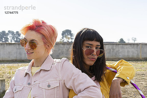 Two alternative friends wearing yellow and pink jeans jackets