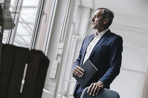 Mature businessman looking out of window