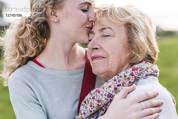 Granddaughter kissing her grandmother