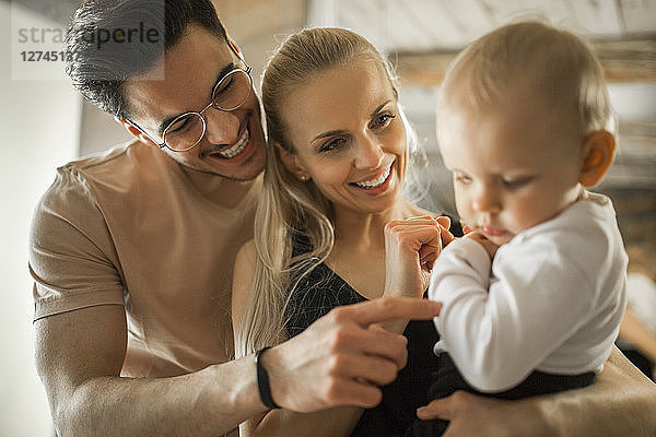 Happy young parents spending time at home with their baby girl