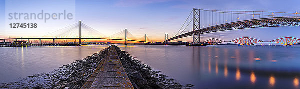 UK  Scotland  Fife  Edinburgh  Firth of Forth estuary  Panorama view from South Queensferry of Forth Bridge  Forth Road Bridge and Queensferry Crossing Bridge at sunset