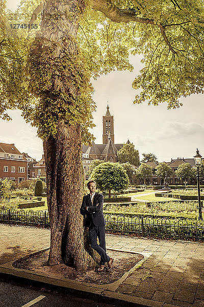 Netherlands  Venlo  businessman leaning against a tree