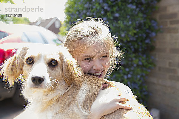 Happy girl hugging dog