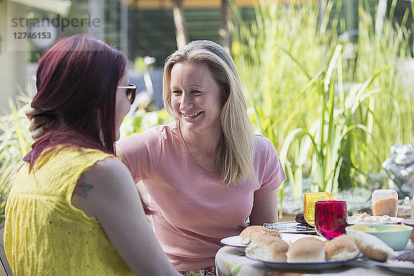 Affectionate lesbian couple enjoying lunch on patio