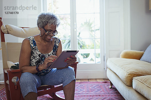 Senior woman using digital tablet in living room