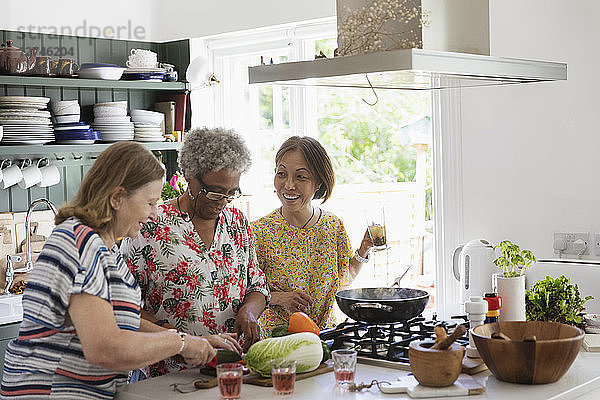 Active senior women cooking in kitchen