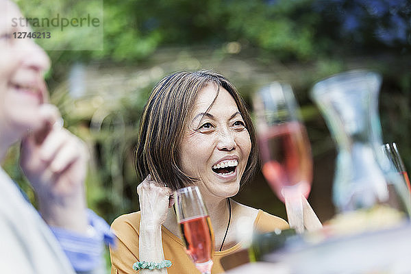 Laughing senior woman enjoying garden party