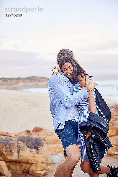 Affectionate couple hugging at beach