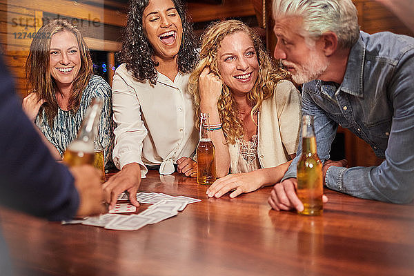 Friends playing card game at cabin table