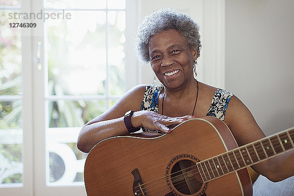 Portrait smiling  confident active senior woman playing guitar