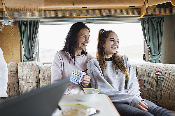 Glückliche Mutter und Tochter genießen das Frühstück im Wohnmobil