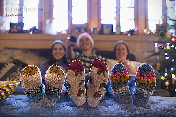 Familie mit bunten Socken  die sich im Wohnzimmer vor dem Fernseher entspannen