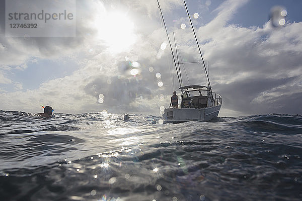 Mann beim Schnorcheln im sonnigen Meer in der Nähe des Bootes  Vava'u  Tonga  Pazifischer Ozean