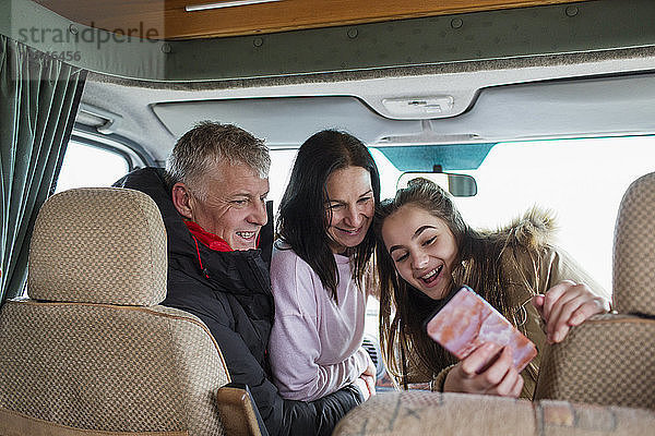 Glückliche Familie mit Smartphone  die ein Selfie im Wohnmobil macht