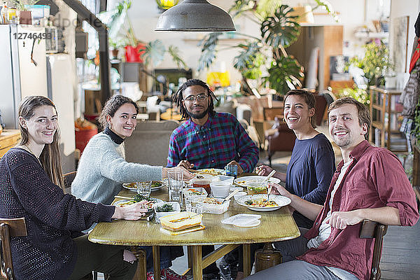 Porträt lächelnd  zuversichtlich  junge Erwachsene Mitbewohner Freunde genießen das Mittagessen am Tisch Wohnung