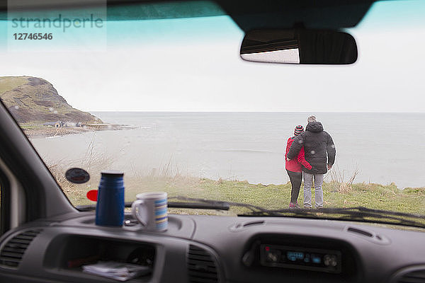 Verliebtes Paar genießt den Meerblick vor dem Wohnmobil