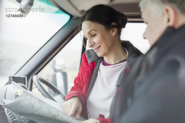 Ehepaar schaut auf Karte im Wohnmobil