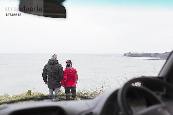 Ehepaar mit Blick auf das Meer außerhalb des Autos