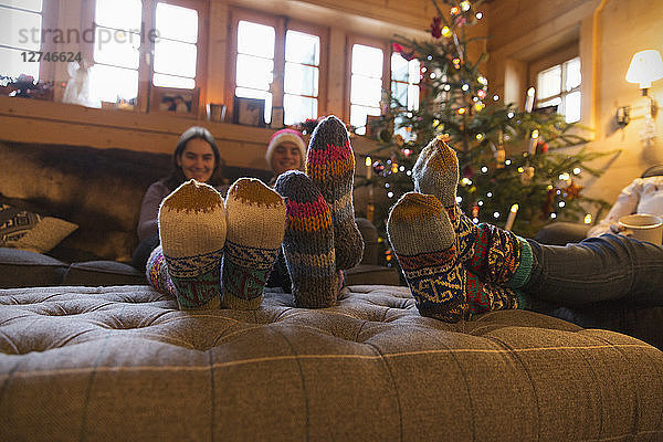 Familie mit bunten Socken entspannt sich im Weihnachtswohnzimmer