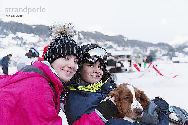 Portrait Bruder und Schwester mit Hund auf der Skipiste