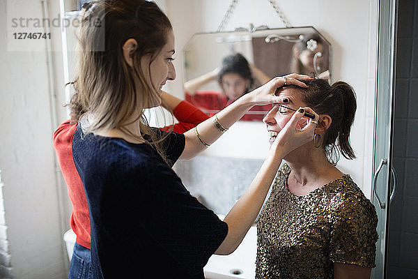 Junge Frauen machen sich bereit und tragen Make-up im Badezimmer auf