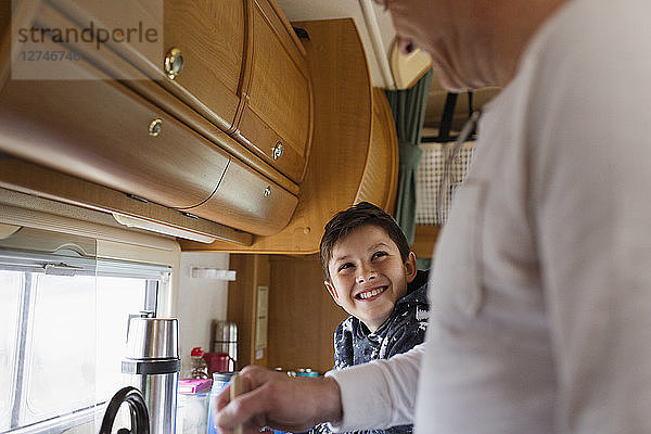 Glücklicher Vater und Sohn beim Kochen im Wohnmobil