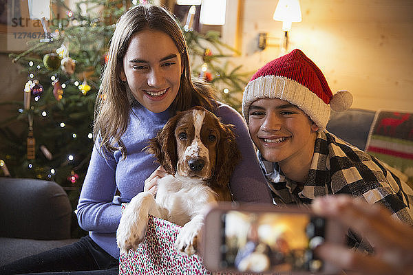 Bruder und Schwester posieren für ein Foto mit Hund in einer Weihnachtsgeschenkbox