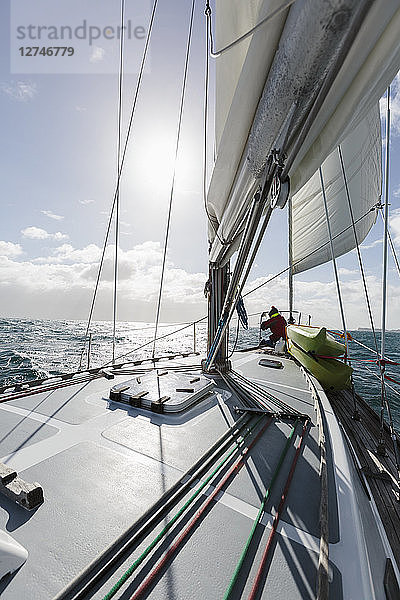 Frau am Bug eines Segelboots auf sonnigem Meer  Vava'u  Tonga  Pazifischer Ozean