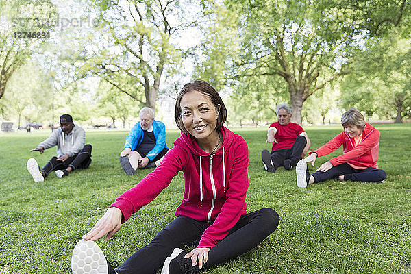 Portrait smiling  confident active senior woman stretching in park