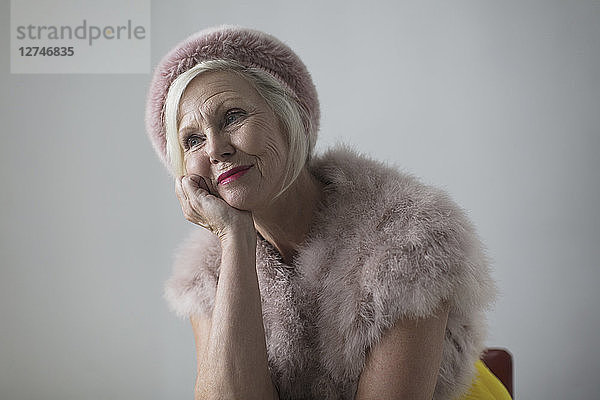 Smiling  nostalgic  elegant senior woman wearing fur