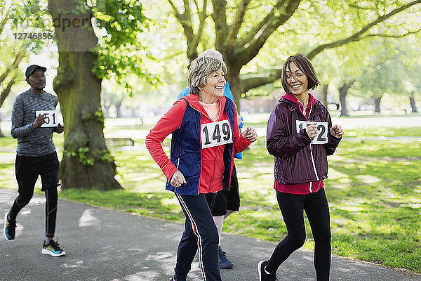 Active senior women friends power walking sports race in park