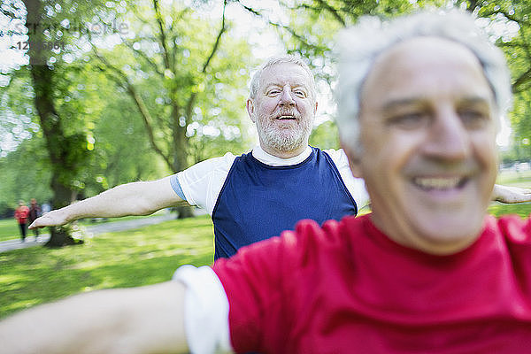 Active senior men exercising  stretching in park