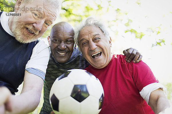 Portrait active senior men friends playing soccer
