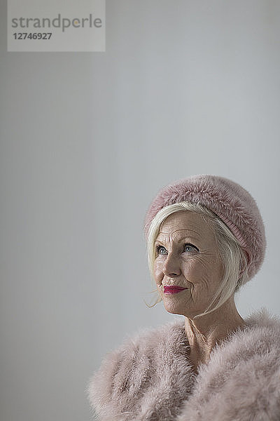 Portrait confident  elegant senior woman wearing pink fur