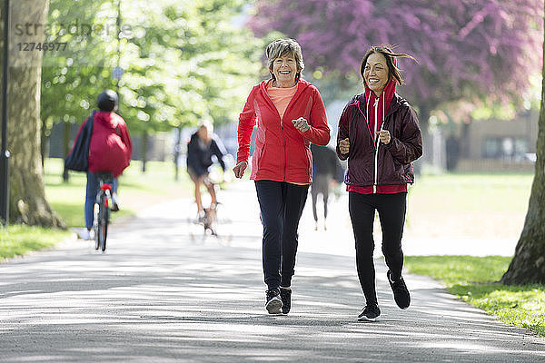 Active senior women friends jogging in park
