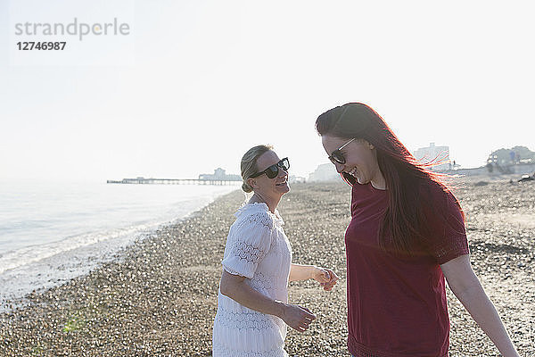 Happy lesbian couple on sunny beach