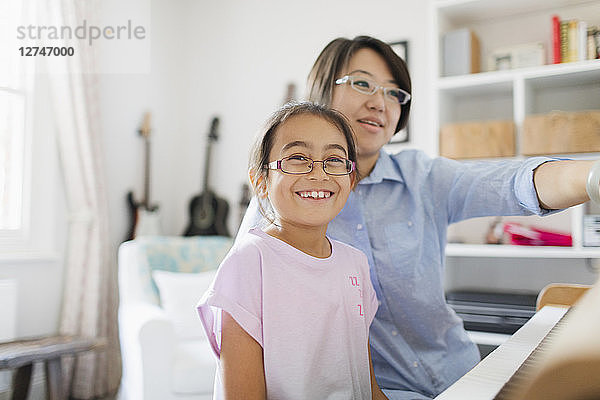 Mother and daughter playing piano