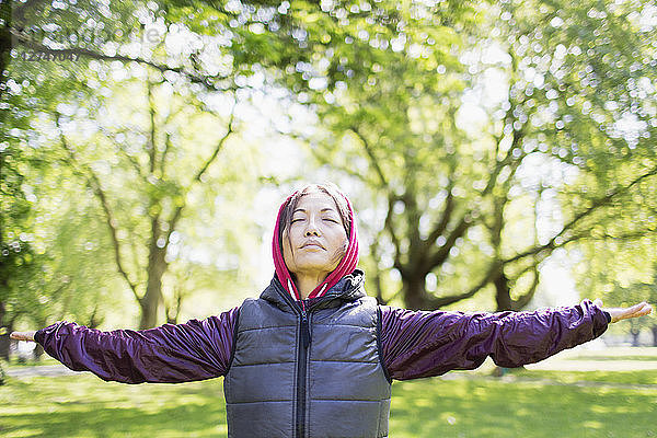Portrait serene active senior woman stretching in park
