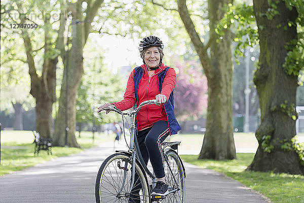 Portrait confident active senior woman riding bike in park