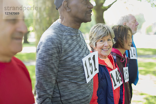 Portrait active senior woman at sports race starting line in park