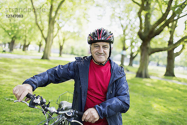 Portrait confident active senior man riding bike in park